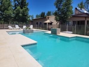 a swimming pool with blue water in a yard at Cabaña premium! in Villa Anizacate