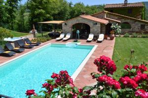 einen Pool mit Liegestühlen und ein Haus in der Unterkunft Sestuccia in Gaiole in Chianti