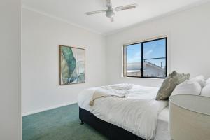 Ένα ή περισσότερα κρεβάτια σε δωμάτιο στο Frangipani At The Bay