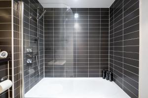 a bathroom with black tiled walls and a shower at Luxury 2Bed Spacious Apartment- City Centre- Free Parking in Birmingham