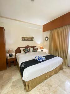 une chambre avec un grand lit dans une pièce dans l'établissement Thomas Coastal Apartment at Jayakarta Residence, à Seminyak