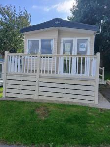 un petit bâtiment avec une clôture blanche dans l'établissement Warm and Cosy, Torbay Waterside Holiday Home, à Paignton
