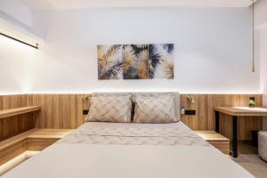 a white bed in a room with wooden walls at Socrates Studios and Suites in Tigaki
