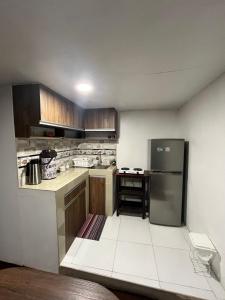 une cuisine avec des armoires en bois et un réfrigérateur en acier inoxydable dans l'établissement Asunta's House, à Calca