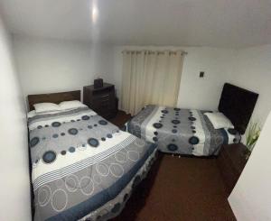 une chambre avec deux lits et une commode dans l'établissement Asunta's House, à Calca