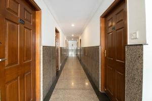a corridor of a hallway with wooden doors at OYO 70156 Victorian Comforts in Bangalore