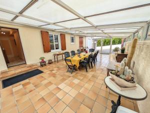 einen Wintergarten mit einem Tisch und Stühlen in einem Zimmer in der Unterkunft Villa Mousse, Maison 4Ch 6 Lits à 17 min du Futuroscope in La Celle-sous-Gouzon