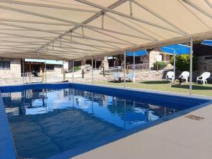 a swimming pool with a tent over it at Cabañas Postal de la Villa in Villa Carlos Paz
