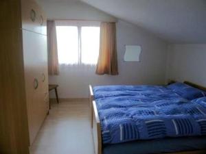 a bedroom with a blue bed and a window at Rehalp Osten in Bischofszell