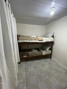 ein Zimmer mit einem Bett auf einem Regal neben Vorhängen in der Unterkunft Casa térreo in São José dos Pinhais