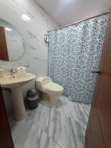 une salle de bain avec toilettes, lavabo et douche dans l'établissement La última parada del Alauseño, à Alausí