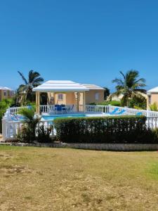 a house with a swimming pool and palm trees at Modern Studio in Pelican with pool-walk to Beach, Dining, Entertainment in Simpson Bay