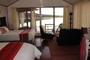 Cette chambre d'hôtel comprend 2 lits et offre une vue sur l'eau. dans l'établissement Uros Titicaca Floating Bed, à Puno