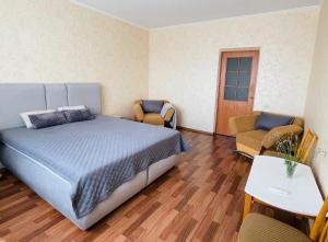 ein Schlafzimmer mit einem Bett und einem Tisch und Stühlen in der Unterkunft Затишна однокімнатна квартира Глеваха in Glevakha
