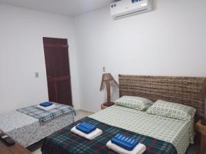 a bedroom with two beds with towels on them at Almar Maragogi in Maragogi