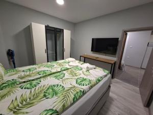 a bedroom with a bed with a green and white comforter at Numbers in Ruse