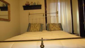 Una cama con cabecero de metal en un dormitorio. en The Historic Argo Hotel, en Crofton