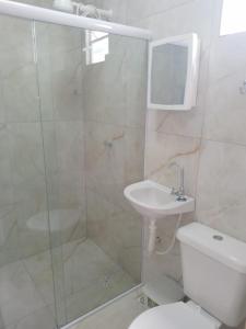 a bathroom with a shower and a toilet and a sink at Almar Maragogi in Maragogi
