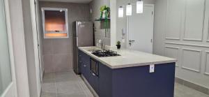 une cuisine avec un évier et un réfrigérateur dans l'établissement Apartamento Novo em São Lourenço, à Bertioga
