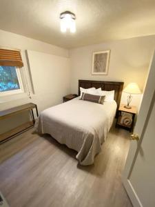 a bedroom with a white bed and a window at Charming Yosemite Basecamp - Walk to Downtown in Mariposa