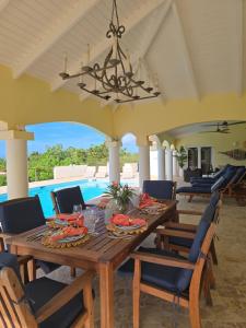 ein Esszimmer mit einem Holztisch und Stühlen in der Unterkunft Private Family Paradise Villa Ocean View With Private Pool in Kralendijk