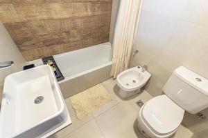 a bathroom with a toilet and a sink and a tub at Departamento parque Saavedra in La Plata +31 photos