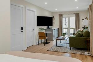 a living room with a couch and a tv at Glenbrook Suites in Stamford