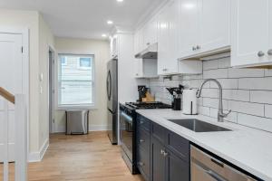 a white kitchen with a sink and a stove at Glenbrook Suites in Stamford