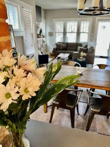 un salon avec un vase de fleurs sur une table dans l'établissement Owen Bungalow II - OKC Paseo - HOT TUB & Fire Pit, à Oklahoma City