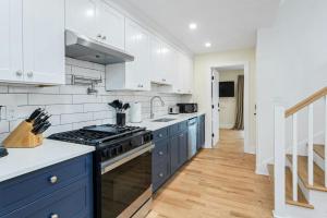 a kitchen with white cabinets and a stove top oven at Glenbrook Suites in Stamford +9 photos