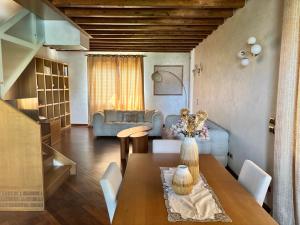 ein Wohnzimmer mit Tisch und Couch in der Unterkunft Brixia Garda Homes in Rezzato