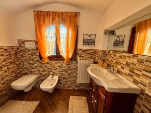 ein Badezimmer mit zwei Waschbecken und einer Toilette und einem Fenster in der Unterkunft Brixia Garda Homes in Rezzato + 62 Fotos