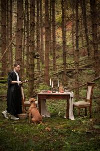 Ein Mann steht neben einem Tisch mit einem Hund in der Unterkunft Agriturismo Bon Tajer 