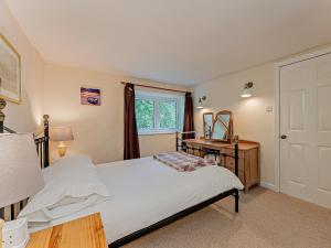 a bedroom with a bed and a desk and a window at 2 Bed in Machynlleth 93078 in Cemmaes