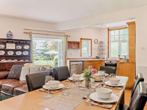 a dining room with a table and a kitchen at 3 Bed in Machynlleth 93080 in Cemmaes