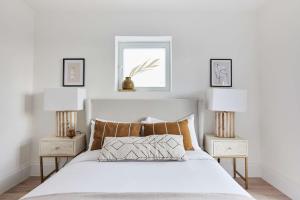 a bedroom with a white bed with two night stands at 2-Bed Apartments a Short Walk to Wembley Stadium in London