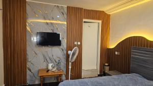 a bedroom with a bed and a tv on a wall at Residence Annapurna Indian in Dakar