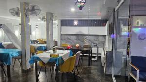 a restaurant with tables and chairs with blue table cloth at Residence Annapurna Indian in Dakar