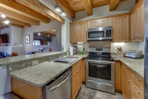 une cuisine avec des armoires en bois et des appareils en acier inoxydable dans l'établissement Ski, Hike and Fish! Beautiful Retreat Near Taos, à Valdez