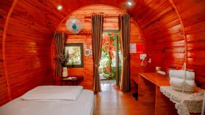 a bedroom with a bed in a wooden room at Home of bong & gao in B'su M'rac