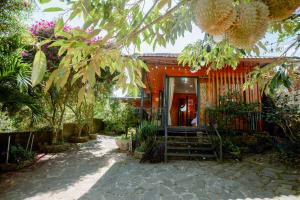 a house with a porch with plants and trees at Home of bong & gao in B'su M'rac