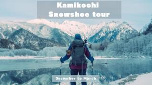 a person with a backpack standing in front of a mountain at Raicho Onsen Inn in Matsumoto