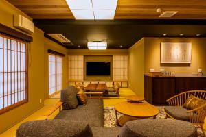 een woonkamer met een bank en een tv bij Nishiyama Ryokan - Established in 1953 in Kyoto