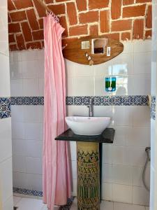 HarqalahにあるL'artisanのバスルーム(シンク、ピンクのシャワーカーテン付)