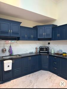 a kitchen with blue cabinets and a sink at Cozy Home for Family, Friends & Work Trips in Buon Ma Thuot