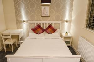 une chambre avec un lit blanc avec deux oreillers dans l'établissement Spacious Modern 5 bedroom home near Heathrow Windsor, à Canvey