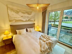 een slaapkamer met een bed en een groot raam bij PIERSIDE - Pier 2 in Haffkrug +22 foto's