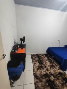 une chambre avec un bureau, un lit et un tapis dans l'établissement Casa completa na Enseada, Guarujá, à Guarujá