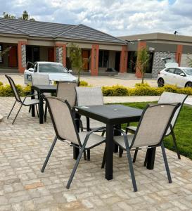 a group of tables and chairs on a patio at EuniBot Guest House in Francistown