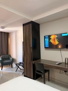 a room with a desk and a tv on the wall at EuniBot Guest House in Francistown